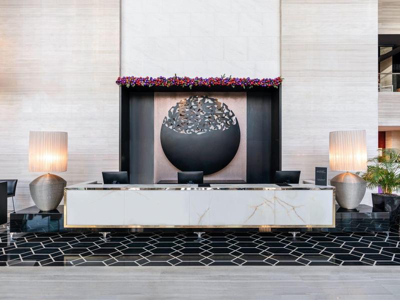 Moderne hotel lobby met een grote bolvormige waterpartij en geometrisch tapijtontwerp.