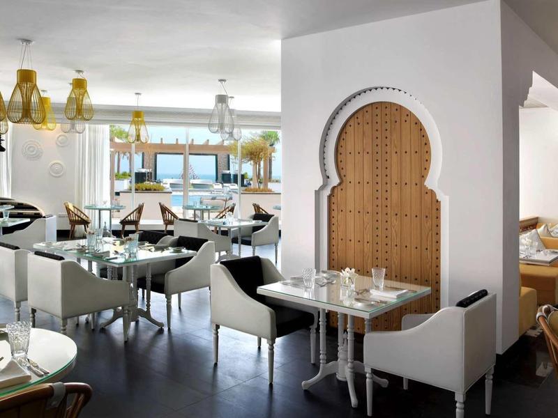 Elegantes Restaurant mit modernen Möbeln und dekorativer Wandnische in warmen Holztönen.