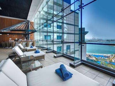 Moderní hotelová terasa s pohodlnými lehátky a úchvatným výhledem na moře.