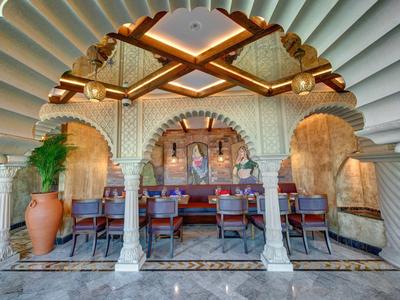 Elegantní jídelní prostor s orientálním designem a dekorativními oblouky v hotelu.