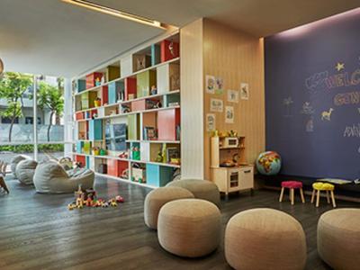 Moderner, heller Lernraum mit buntem Bücherregal, Sitzsäcken und kreativ gestalteter Wand.