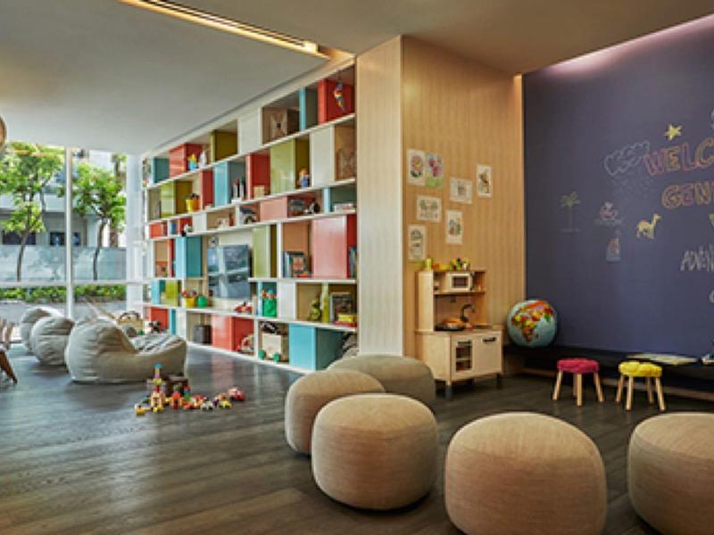 Moderner, heller Lernraum mit buntem Bücherregal, Sitzsäcken und kreativ gestalteter Wand.