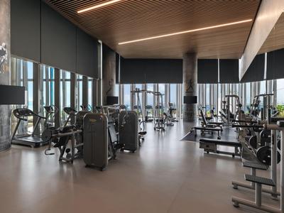 Modern gym with various exercise machines and large windows
