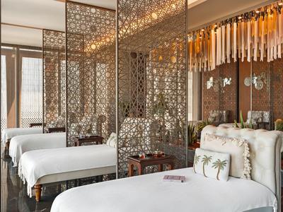 Habitación de hotel elegante con camas blancas y paredes decorativas espejadas