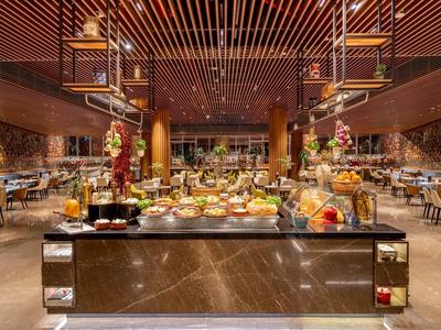 Großzügiges Buffet in einem eleganten Hotelrestaurant mit warm beleuchtetem Holzdekor.