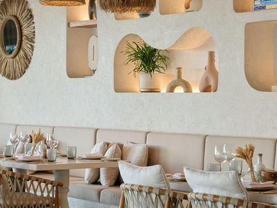 Modernes Hotelrestaurant mit weißen Wänden, dekorativen Nischen und gemütlichen Sitzgelegenheiten.
