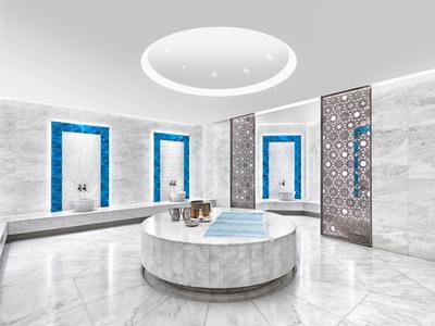 Modernes Spa mit rundem zentralem Marmorbecken, grauen Wänden und blau akzentuierten Türen.