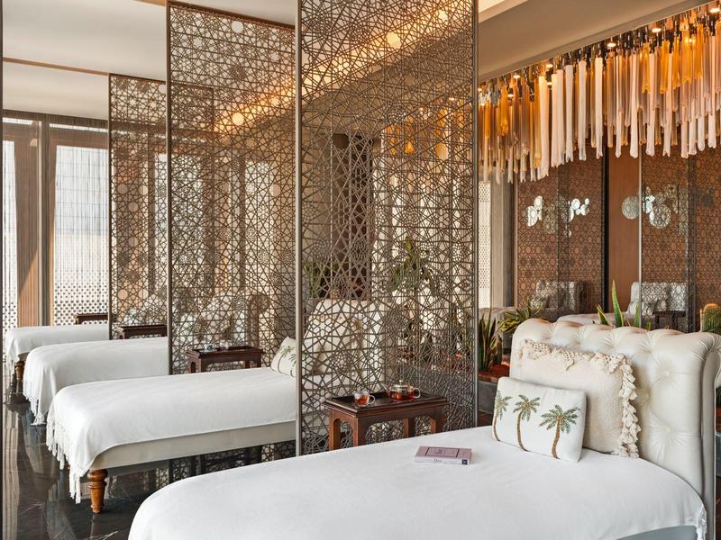 Habitación de hotel elegante con camas blancas y paredes decorativas espejadas