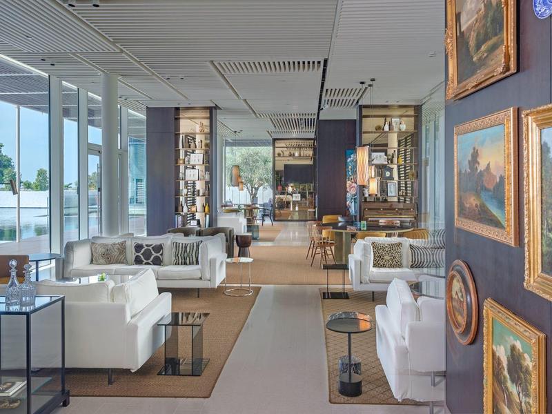 Modern eingerichteter Hotellobby-Bereich mit Sofas, Kunstwerken an der Wand und großen Fenstern.