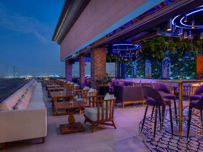 Moderní hotelový bar s pohodlným posezením a výhledem na noční město.