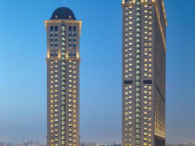 Verlichte twee wolkenkrabbergebouwen bij schemering met heldere lucht