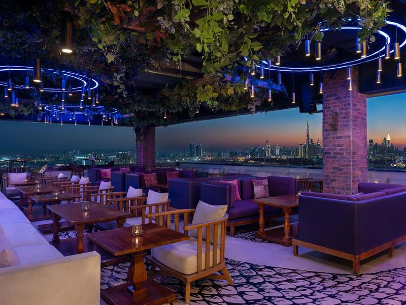 Dakterras met zitgedeeltes en stadszicht bij schemering