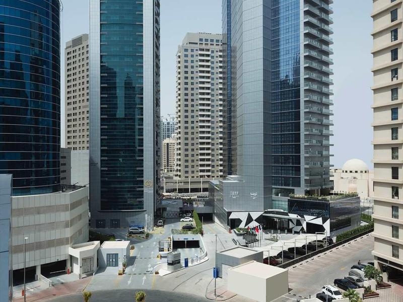 Edificios altos y modernos con fachadas de vidrio en un entorno urbano con cielo despejado.