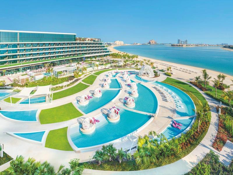 Modernes Ferienresort mit geschwungenem Pool und direktem Meerblick.