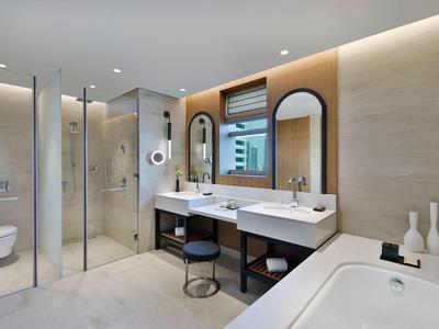 Salle de bain moderne avec deux lavabos, grande baignoire et douche à l'italienne en verre.