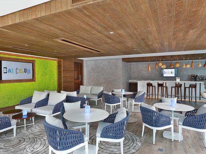 Bar d'hôtel moderne avec tables blanches, chaises bleues et plafond en bois.
