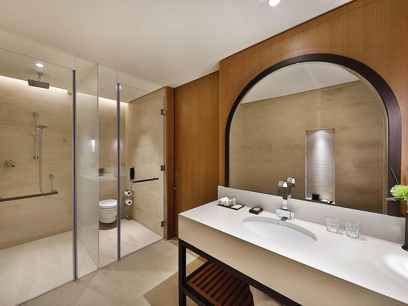 Salle de bain moderne avec douche à l'italienne, lavabo, miroir et accents en bois.