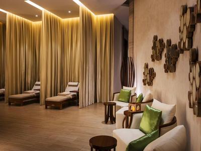 Elegante hotel lounge met comfortabele fauteuils, bijzettafels en warm indirect licht.