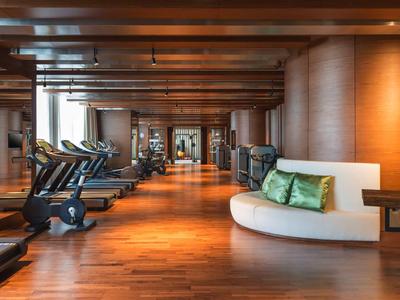 Gimnasio moderno con cintas de correr y diseño elegante de madera en un hotel.