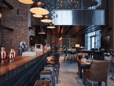 Modern café met barkrukken, leren stoelen en grote industriële lampen.