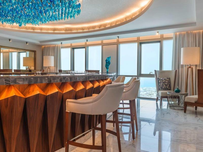 Moderne hotelbar met strakke barkrukken en groot panoramisch raam.