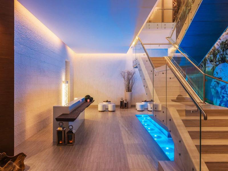 Moderne buitenruimte met verlichte trap en buitenspa 's nachts.