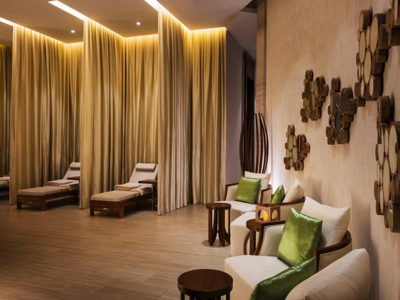 Elegante hotel lounge met comfortabele fauteuils, bijzettafels en warm indirect licht.