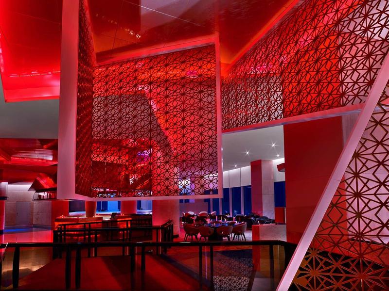 Ristorante moderno con illuminazione rossa e arredi in legno eleganti.