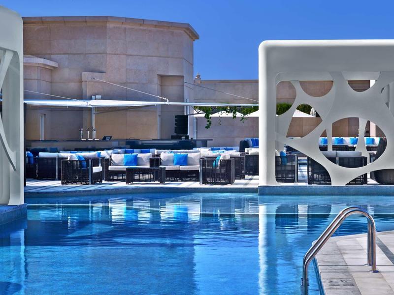 Area piscina illuminata con design moderno ed elementi architettonici di notte.