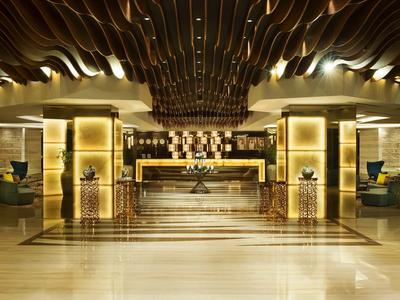 Lobby de hotel lujosa con detalles dorados modernos y decoración de techo de madera curva