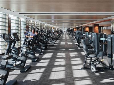 Grande palestra con attrezzature moderne e luce naturale da grandi finestre.