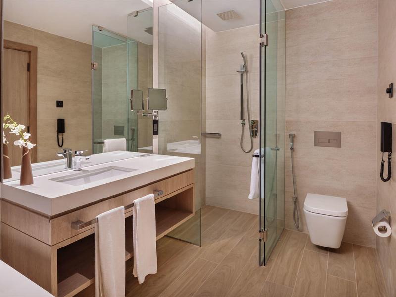 Colorful water playground with slides and spray features under a blue sky.