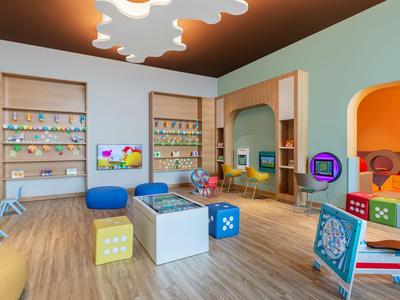 Bunter, moderner Kinderbereich mit Spielwürfeln, Sitzkissen und Spielzeug in einem Hotel.