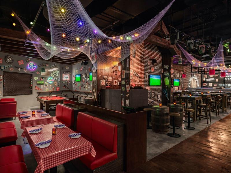 Gemütliches Restaurant mit rot karierten Tischdecken, roten Sitzbänken und dekorativer Deckenbeleuchtung.