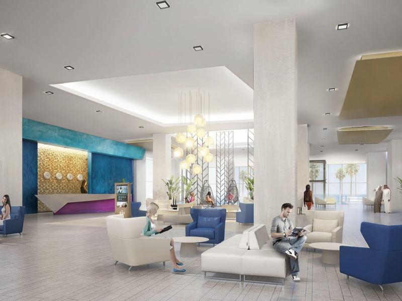Spacious modern hotel lobby with seating areas, white and blue furniture, and reception desk.