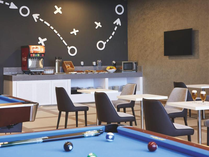 Game room with pool table and seating area in modern design, tactic board on the wall.