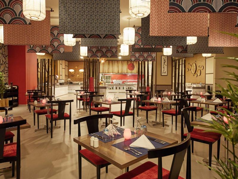 Cozy restaurant area with modern Asian design and set tables.