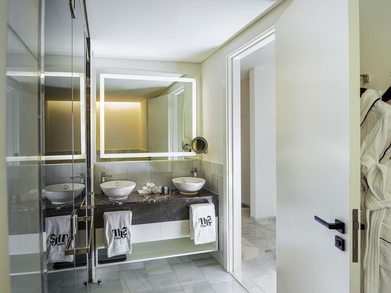 Moderner Badezimmerspiegel mit LED-Beleuchtung über Doppelwaschbecken und hellen Wänden.