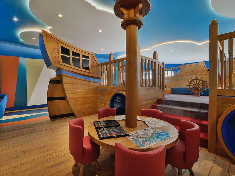 Kinderspielbereich mit Piratenschiff-Thema und Sitzbereich in buntem Interieur