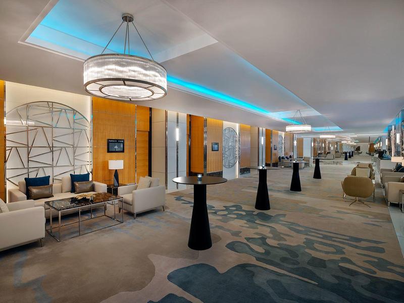 Großer moderner Hotellobby-Bereich mit Sitzgelegenheiten und Beleuchtung.