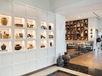 Moderne Hotellobby mit beleuchteten Regalen und Sitzbereich mit Holzboden