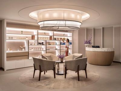 Eleganter Lounge-Bereich mit Sesseln, runder Beleuchtung und einem Empfangstresen in einem Hotel.