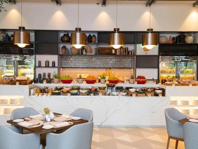 Modernes Buffet mit vielfältigen Speisen, gemütlichen Tischen und warmem Licht in elegantem Ambiente.