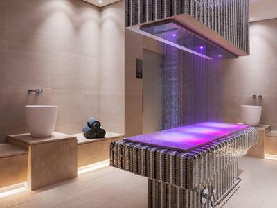 Modern spa area with illuminated waterfall and relaxing treatments