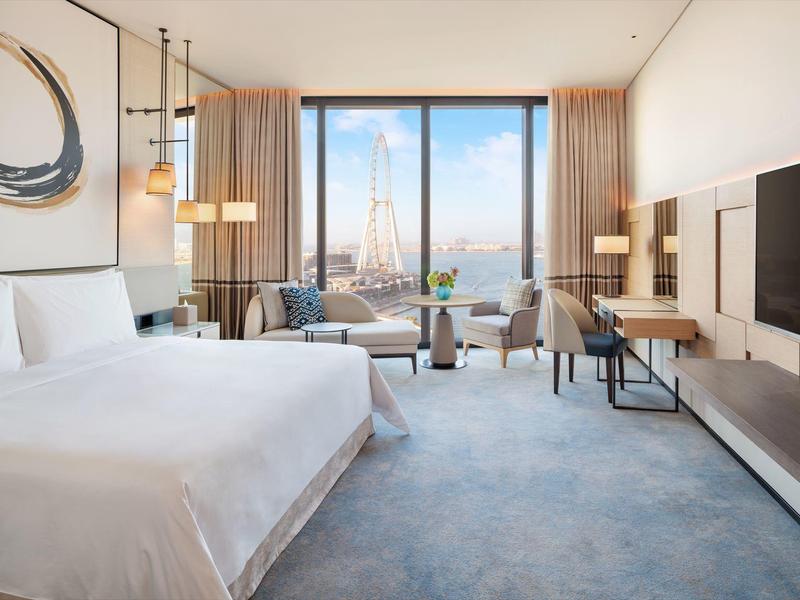 Modern hotel room with a large bed and view of the Eiffel Tower.