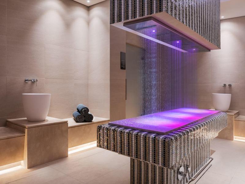 Modern spa area with illuminated waterfall and relaxing treatments