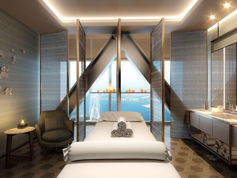 Modern spa room with massage table and view of water and city skyline.