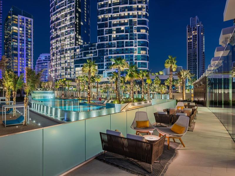 Modern outdoor lounge with seating and city lights at night