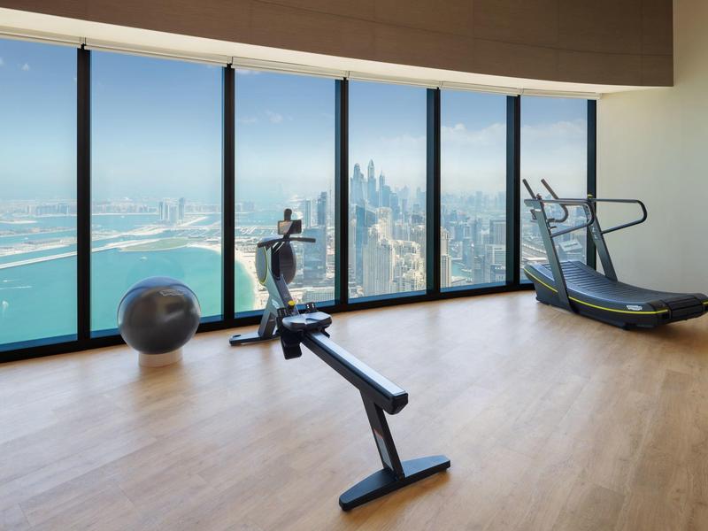 Modern gym room with city and sea view through large windows
