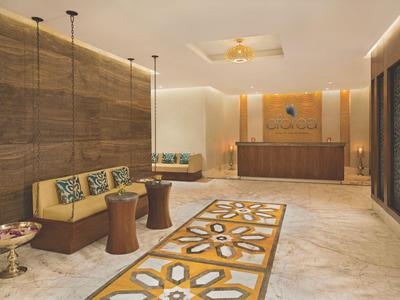 Moderne Hotellobby mit Holzwänden, Teppichläufern und Empfangstheke in warmem Licht.
